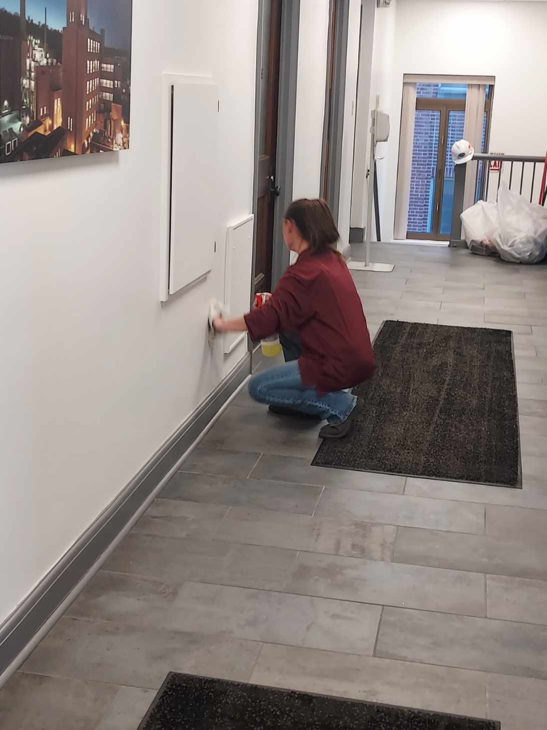 a woman cleaning baseboards